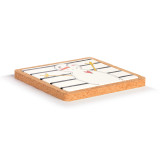 Side view showing the depth of a square ceramic trivet with horizontal black lines and a snowman sitting in a cork base.