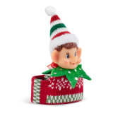 Closed view of a slap bracelet in a red and green knit pattern with the head of a light skinned elf in the middle, displayed angled to the right.
