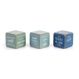 A set of three wood dice painted green and blue that have different family activities on each side, displayed showing different sides of the dice.