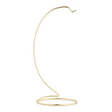 A gold metal ornament stand with a oval base and curved arm that holds one ornament.