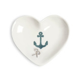 A white ceramic heart shaped trinket dish with an image of an anchor in the middle, displayed with a pair of earrings inside.