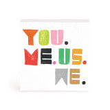 A small white box artwork of the phrase "You. Me. Us. We." colored in different colors.