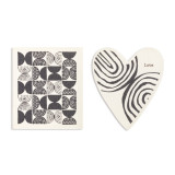 Two black and white biodegradable dish cloths. One is heart shaped with black lines and the word "love" and the other is white with black geometric designs.