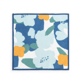 A double sided square dish cloth that is white on one side with large blue floral illustrations.