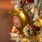 A gold ornament with a QR code hanging on a white frosted lit Christmas tree. A gold ornament with a QR code hanging on a white frosted lit Christmas tree.