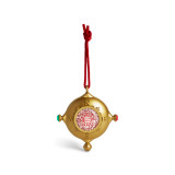 A gold ornament that looks a bit like a compass on a red hanger. There is a QR code in the center to scan for videos.