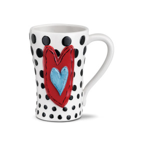 White coffee mug with black polka dots and red heart with light blue heart centered