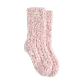 A pair of light pink fuzzy socks with a small cream Giving Collection fabric tag attached.
