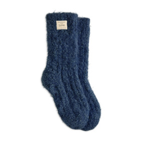 A pair of navy fuzzy socks with a small cream Giving Collection fabric tag attached.