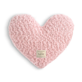 A light pink heart shaped Giving Collection pillow with a small cream Giving Collection fabric tag attached.