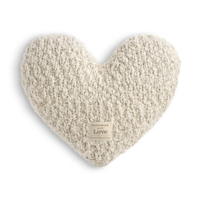 A cream heart shaped Giving Collection pillow with a small cream Giving Collection fabric tag attached.