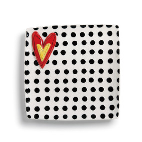 White and black polka dot plate with red heart with yellow heart inside on the left side