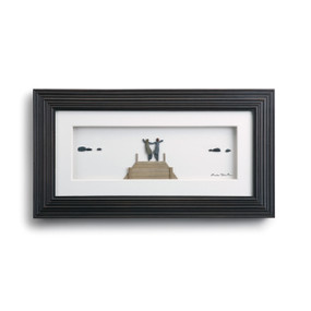 Horizontal wooden outline frame, inside is white with figurines holding hands walking on bridge