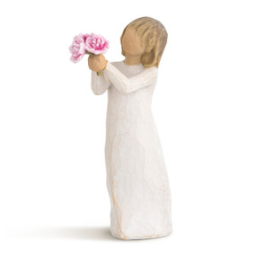 Left view of standing figure with short light hair in cream dress holding out bunch of pink peonies