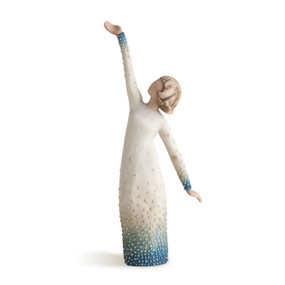 Front view of standing female figure with one arm raised and one down, wearing cream dress with blue ombre and golf-leaf dots around bottom