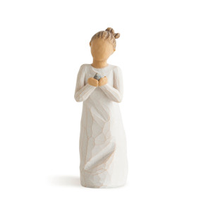 Front view of standing figure in cream dress with hair in a bun holding a small bluebird in hands