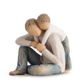 Front view of seated male figure in light gray shirt and blue jeans holding hands with younger boy in cream shirt and blue jeans leaning over his back