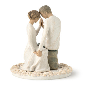 Seated male and female figures with heads and hands touching, on flat round base decorated with carved roses