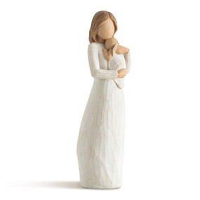 Front view of standing female figure in cream dress holding infant in cream blanket to her chest