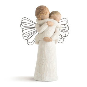 Front view of figure of female in cream dress with wire wings, holding baby in cream onesie