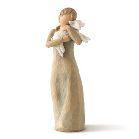 Front view of female figure in olive dress, holding baby lamb in arms
