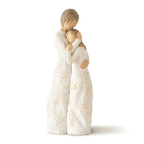 Front view of two standing female figures embracing in cream dresses carved with vines and leaves, one younger and one older