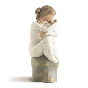 Front-right view of female figure in cream dress, seated on rock, holding newborn baby wrapped in blanket