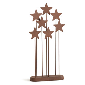 Seven rust-colored metal stars, each atop a metal rod of varying height and affixed to rust-colored metal base