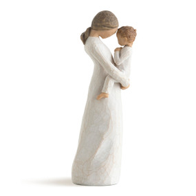 Side view of standing female figure in cream dress, holding toddler in front of her, touching heads