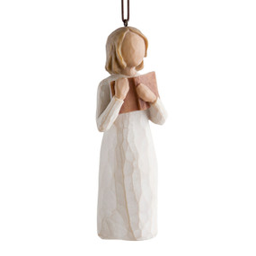 Female figure in cream dress, holding open book to her chest, ornament hook and loop attached to head