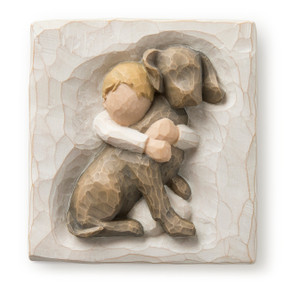 Flat square cream-colored plaque with bas-relief carving of young boy hugging large dark dog