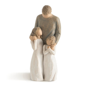 Front view of standing male with in gray shirt and dark pants with arms around two youger girl figures standing in front of him