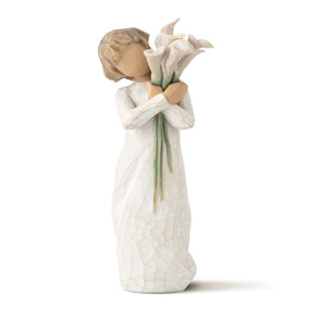 Front view of standing figure in cream dress holding tall bouquet of white calla lillies