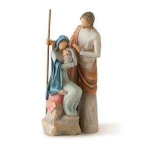 Front view of seated female figure in light blue dress and blue cloak holding baby, with male figure in rust-colored cloak standing behind her holding staff
