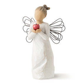 Front view of standing female figure in cream dress with wire wings holding out red apple in hands