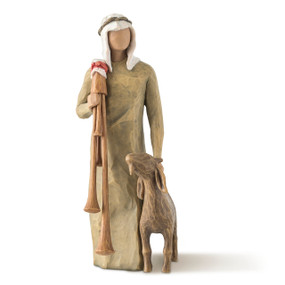 Front view of male figure in olive dress with brown goat at side, carrying set of wooden bagpipes over shoulder