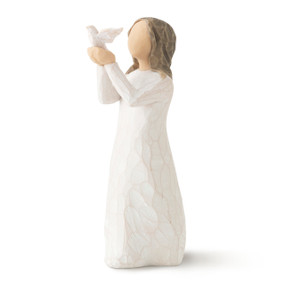 Front view of standing figure in cream dress holding small white bird out in hands