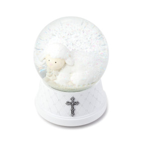 White snowglobe with small lamb figurine inside with snowflakes - bottom of globe has silver cross put on it