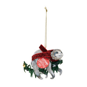 Side view of silver sloth ornament riding green branch wearing red scarf