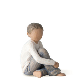 Front view of seated figure wearing blue jeans and cream shirt, with arms around raised knee