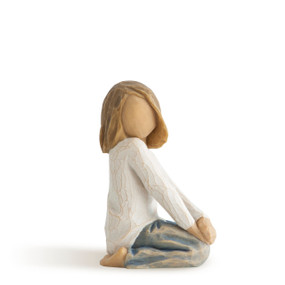 Right view of kneeling girl in cream shirt and blue jeans with hands on knees