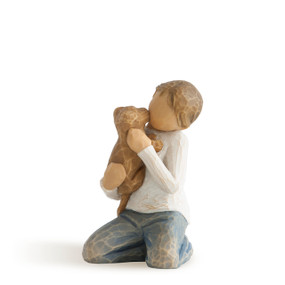 Front view of kneeling boy in cream shirt and blue jeans, holding golden dog in his arms