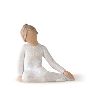 Front view of side-seated girl figure with hair in bun in cream dress leaning on hand