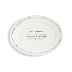 white ceramic round dish with sentiment etched into it with black rings around edges