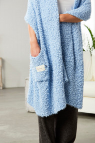 Close view of light blue giving shawl with woman's arms inside