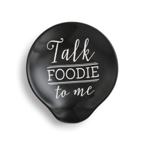 Black ceramic spoon rest with "Talk Foodie to me" in white.
