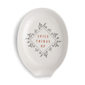 white ceramic spoon rest with the words 'spice things up'in red  outlined with herb design in black