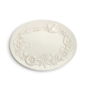 An oval serving platter with a spring Easter scene engraved around the edge.