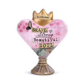 A pink heart sculpture with a golden crown. Reads "brave strong beautiful soul".
