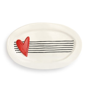 A cream oval serving platter with black stripes and a large red heart.